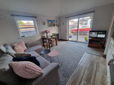 a living room with a couch and a tv at The Auld Byre - by the Beach in Dumfries