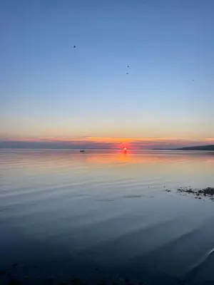 a large body of water with a sunset in the background at Immaculate 2-Bed Lodge in Monreith in Newton Stewart