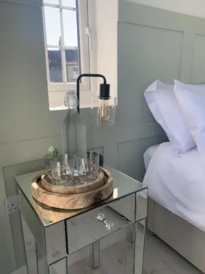 a glass table with a bowl of glasses on it next to a bed at Luxury Cottage, views of the Lakes with Hot Tub in Cockermouth
