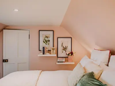 a bedroom with a white bed and two pictures on the wall at Fawn's Velvet in Enoch