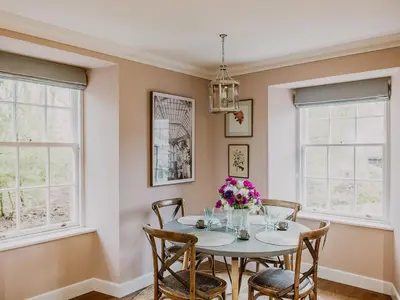 a dining room with a table and chairs and windows at Fawn's Velvet in Enoch