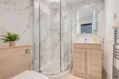 a bathroom with a shower and a toilet and a sink at Cottage 1, Old Farmhouse Mews in Braithwaite