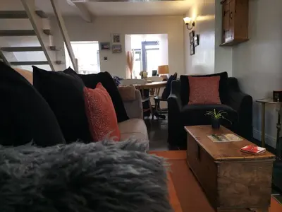 a living room with couches and a table at Mill Cottage modern cosy Lake District home with open fire near Scafell in Gosforth