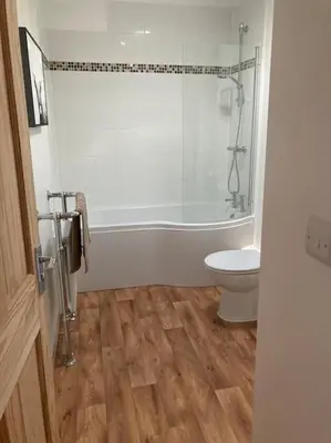a bathroom with a tub and a toilet and a shower at Marni’s Cottage - Rural location & fell views in Frizington