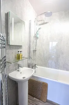 a bathroom with a sink and a shower and a tub at Dalegarth House Portinscale in Keswick