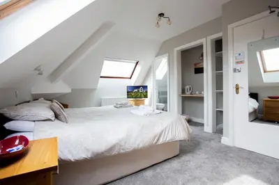 a bedroom with a large white bed and a desk at Dalegarth House Portinscale in Keswick