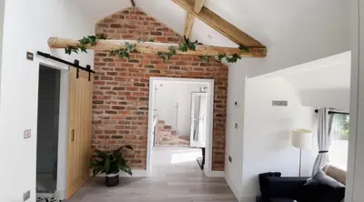 a living room with a brick wall at The Sty & The Stable in Carlisle