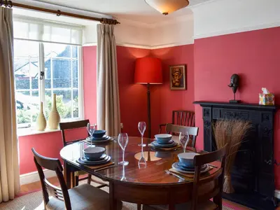 a dining room with a table and a red wall at Hey Down in Keswick