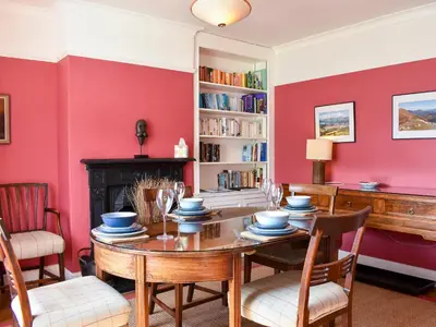 a dining room with red walls and a table and chairs at Hey Down in Keswick