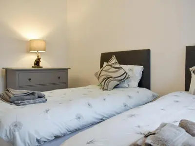 a bedroom with two beds and a lamp on a table at Helvellyn House in Keswick