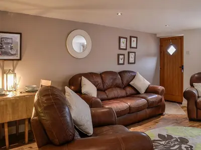 a living room with a leather couch and a table at The Annex in Crosby