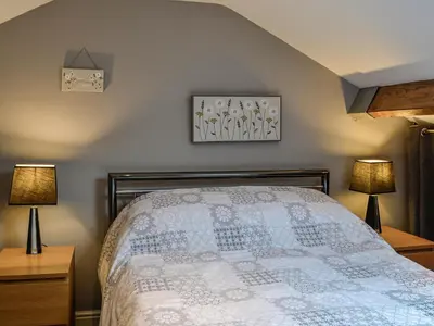 a bedroom with a bed with two lamps on tables at The Annex in Crosby