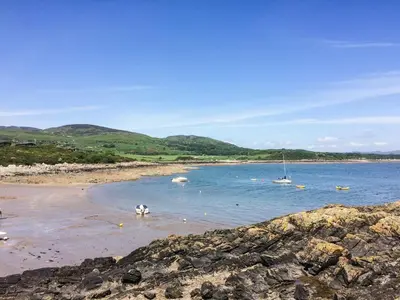a beach with two boats in the water at Kerrim Cottage in Ringford