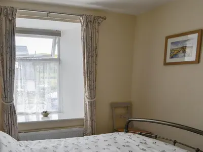 a bedroom with a bed and a window at Kerrim Cottage in Ringford