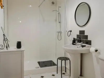 a white bathroom with a sink and a mirror at Church Cottage in Rigg
