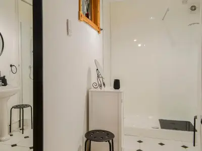 a bathroom with a white tub and two stools at Church Cottage in Rigg
