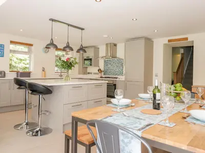 a kitchen with a wooden table and a dining room at Ladstock Cottage in Keswick