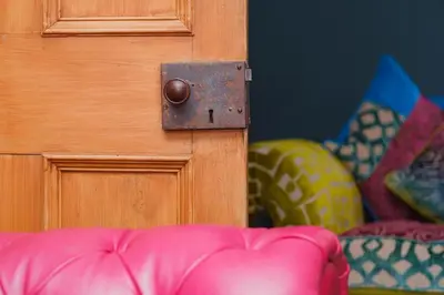 a close up of a wooden door with a pink couch at Tig Cottage - a rural, quirky, pet friendly 2 bedroom cottage near Ballantrae in Ballantrae