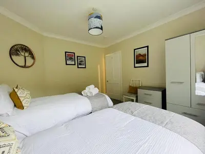 a bedroom with two beds and a mirror at Three Peaks in Braithwaite