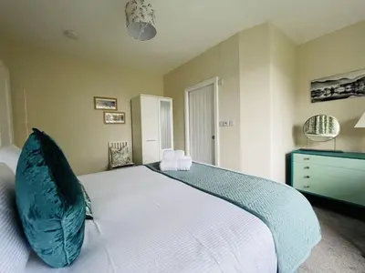 a bedroom with a large bed with a blue pillow at Three Peaks in Braithwaite