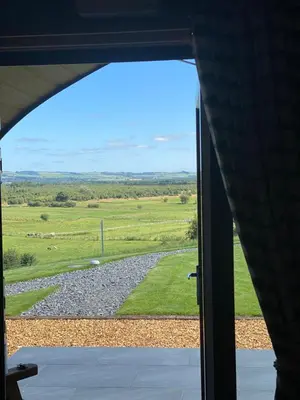 a view of a field from an open window at Craigend Farm Holiday Pods - The Woolly Sheep in Dumfries