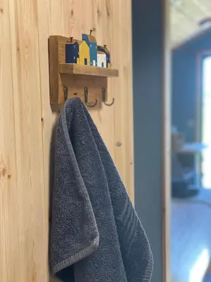 a towel is hanging on a wooden wall at Craigend Farm Holiday Pods - The Woolly Sheep in Dumfries