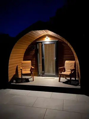two benches sitting on a patio with an archway at Craigend Farm Holiday Pods - The Woolly Sheep in Dumfries