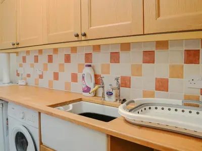 a kitchen with a sink and a washing machine at The Moorings in Lochmaben