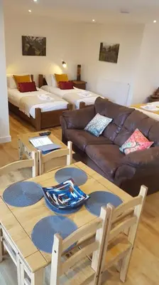 a living room with a couch and a table at Wastwater Cottage on The Big 