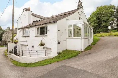 a white house on the side of a road at Woodloft Cottage in Elterwater