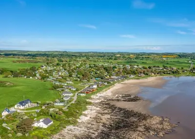 an aerial view of a town next to the beach at Sandgreen Caravan Park in Girthon