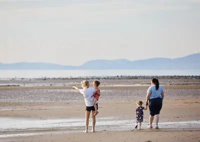 a group of people standing on a beach at Lyons Manor House in Maryport
