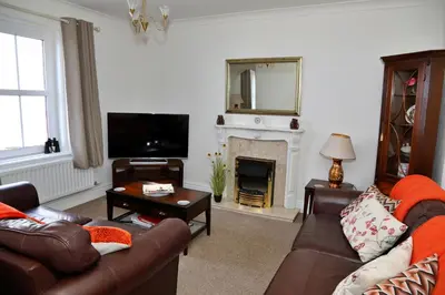 a living room with a couch and a fireplace at Finest Retreats - Glendale in Skinburness