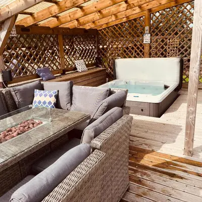 a outdoor patio with a couch and a tub at The Dairy in Castle Douglas