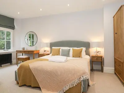 a bedroom with a large bed with a blue headboard at Eller Close House in Ambleside