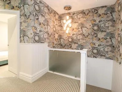 a room with a wall covered in floral wallpaper at Eller Close House in Ambleside