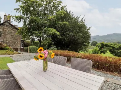 a vase of flowers sitting on a wooden table at Eller Close House in Ambleside
