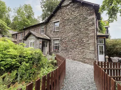 a stone house with a fence in front of it at Eller Close House in Ambleside