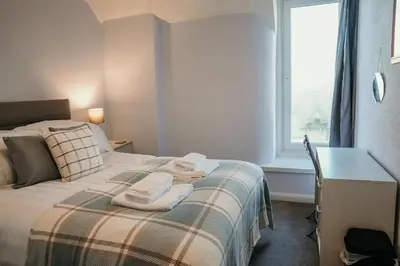 a bedroom with a bed with a desk and a window at 14 Burnett House by Prestige Properties SA in Seascale