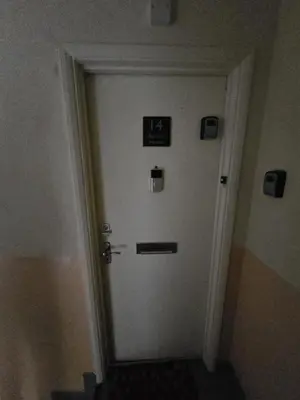 a white door with signs on it in a hallway at 14 Burnett House by Prestige Properties SA in Seascale