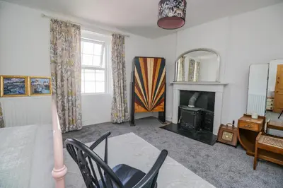 a living room with a bed and a fireplace at 3 Clarks Terrace in Maryport