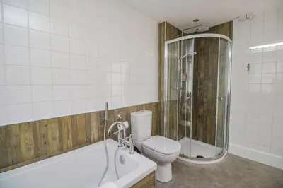 a bathroom with a toilet and a shower and a tub at 3 Clarks Terrace in Maryport
