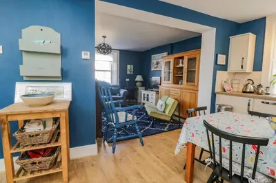 a kitchen and dining room with blue walls and a table at 3 Clarks Terrace in Maryport