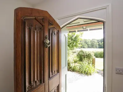 an open door with a view of a yard at Caldhu Cottage in Holmrook