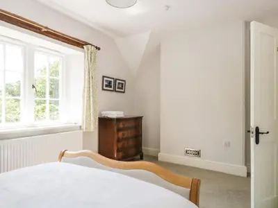 a bedroom with a bed and a window at Caldhu Cottage in Holmrook
