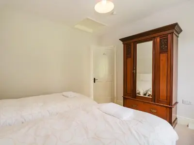 a bedroom with a bed and a dresser with a mirror at Caldhu Cottage in Holmrook