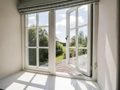 an open window with a view of a garden at Caldhu Cottage in Holmrook