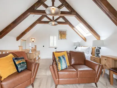 a living room with two leather chairs and a ceiling at The Railway Sleeper in Hyndfordbridge-end