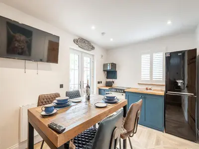 a kitchen with a wooden table and some chairs at The Railway Sleeper in Hyndfordbridge-end