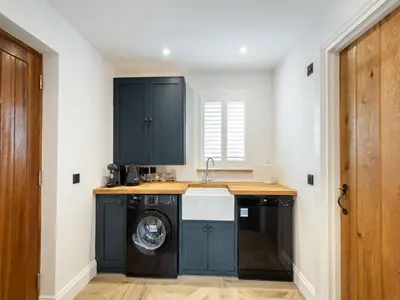 a kitchen with a washing machine and a sink at The Railway Sleeper in Hyndfordbridge-end